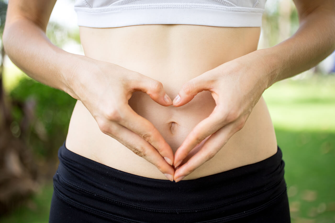 Hands forming a heart over the stomach